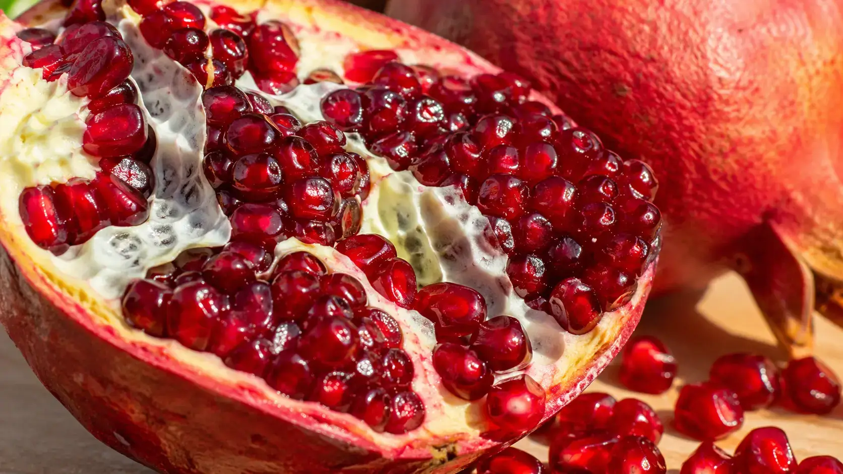 Фото: розрізаний гранат крупним планом, насичено-червоні зерна